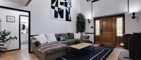 A modern living room with a sofa, coffee table, and a fireplace.