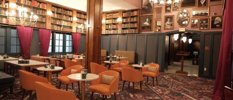 A library with bookshelves, tables, and chairs.