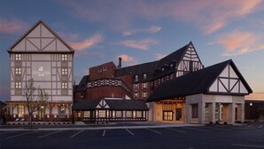 A hotel with a traditional architectural style, featuring a prominent central building with a gabled roof and a smaller annex with a similar design.