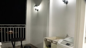 A bathroom with a bathtub, a small stool, and a window with a metal railing. - Apartahotel Tia Inés (Montenegro)