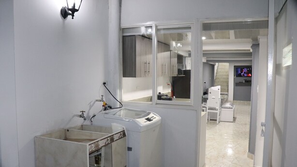 A modern bathroom with a washing machine, a sink, and a mirror. - Apartahotel Tia Inés (Montenegro)
