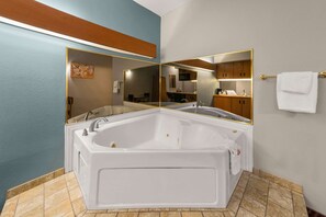 A modern bathroom with a large freestanding bathtub, a vanity with a mirror, and a towel rack.