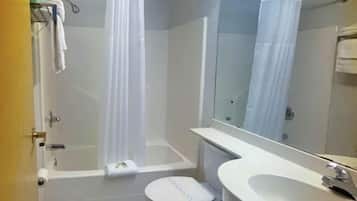 A bathroom with a bathtub, toilet, sink, and a mirror.