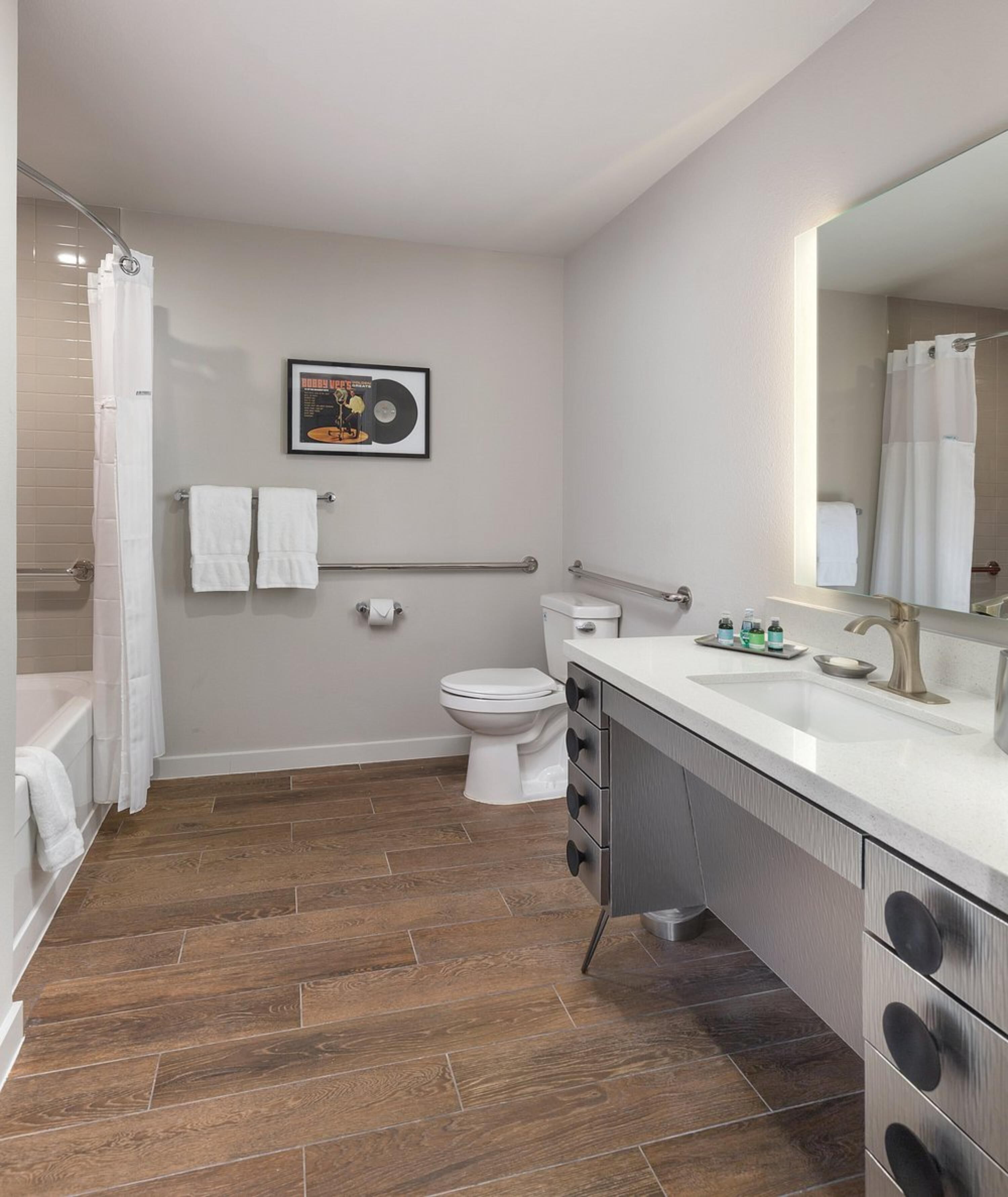A modern bathroom with a shower, toilet, and vanity.