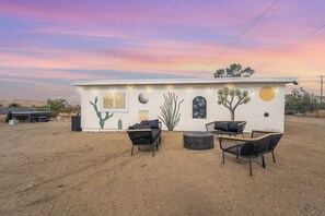 A building with a desert landscape, a cactus mural, and outdoor seating.