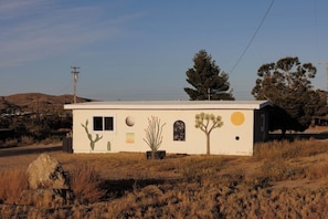 A small building with a flat roof, a cactus mural, and a tree mural. - Desert Escape w/ Hot Tub + Fire Pit | Near Park (Yucca Valley)