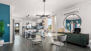 A modern kitchen with a central island, bar stools, and a round mirror above the counter. - Desert Artist Oasis| Fire-pit | Spa | 5 min to JT, Desert Artist Oasis| Fire-pit | Spa | 5 min to (Yucca Valley)