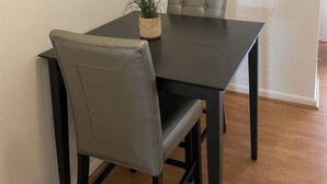 Un comedor con una mesa de madera oscura y una sola silla tapizada en gris.