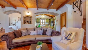 A cozy living room with a sectional sofa, a white armchair, and a coffee table with a plant.