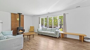 A modern living room with a brick wall, a sofa, a coffee table, and a bench. - Springs / Amagansett area. Walk to bay. Private / 4 bedrooms  (East Hampton)