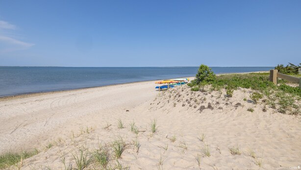 A sandy beach with a clear sky, a wooden fence, and a small bush. - Springs / Amagansett area. Walk to bay. Private / 4 bedrooms  (East Hampton)