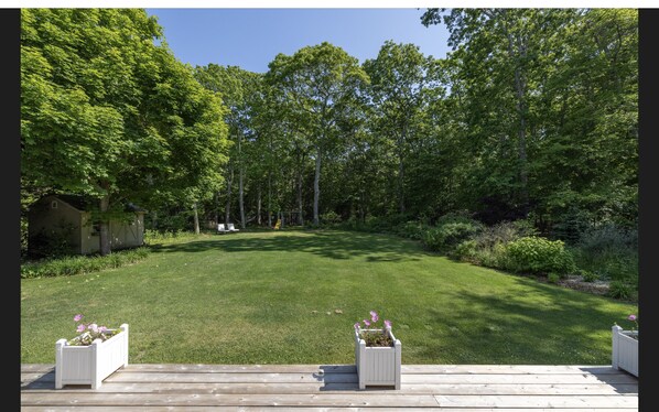 A backyard with a lawn, a wooden deck, and a small shed. - Springs / Amagansett area. Walk to bay. Private / 4 bedrooms (East Hampton)