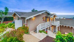 A two-story house with a balcony, a small porch, and a well-maintained garden. - Villa Solamar-Sunset Cliffs Spectacular (San Diego)