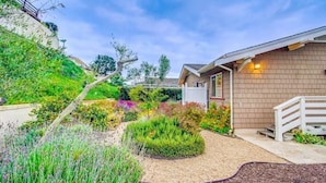 A residential house with a well-maintained garden, a brick exterior, and a white front porch. - Villa Solamar-Sunset Cliffs Spectacular (San Diego)