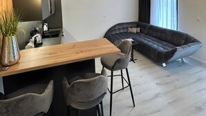 Ett modernt kök med en bänkskiva i trä, barstolar och hängande lampor.