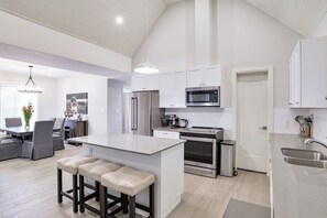 Enjoy cooking and dining in this well-equipped kitchen with a central island, bar stools, and ample counter space.