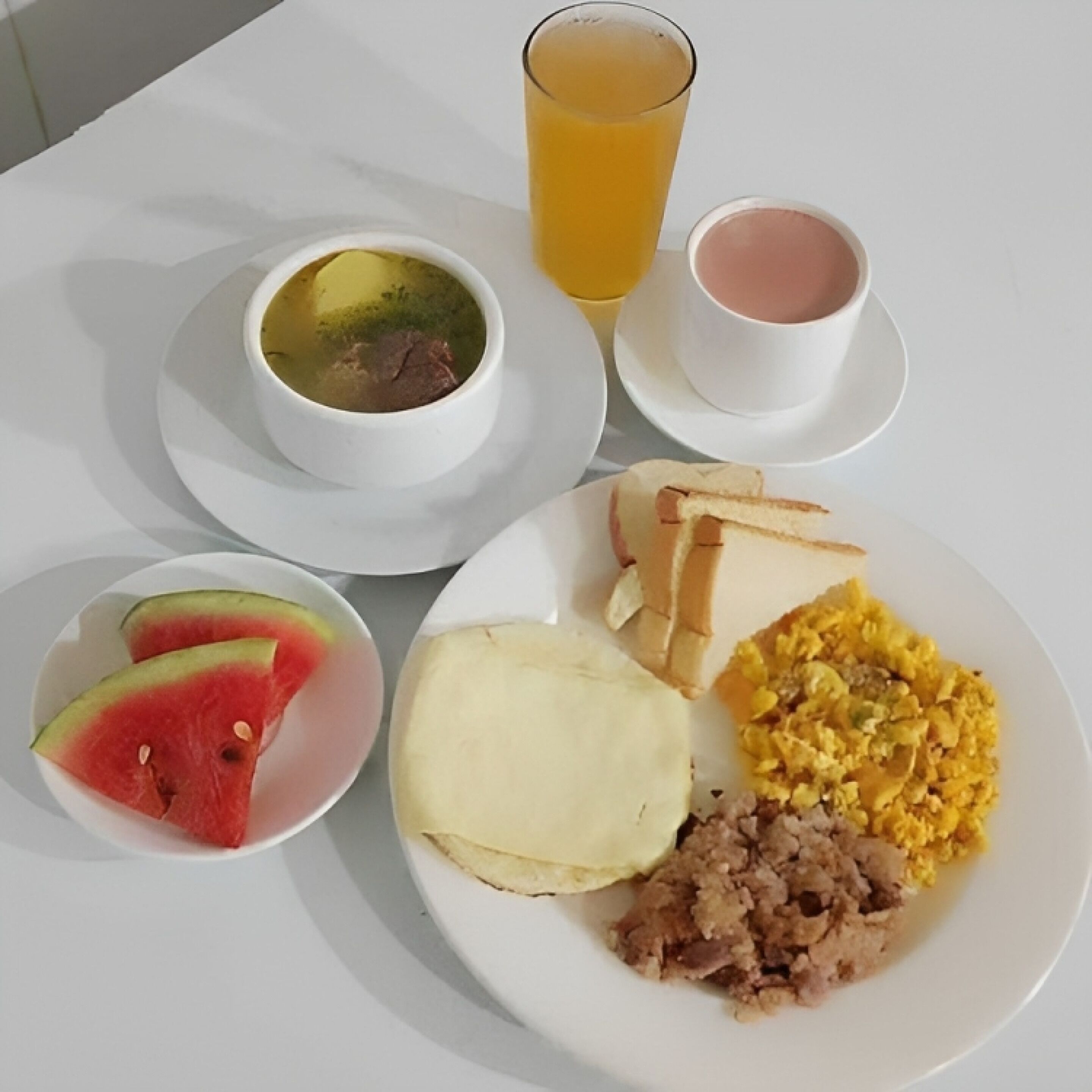 Une assiette de petit-déjeuner avec des toasts, des œufs brouillés et une portion de viande.