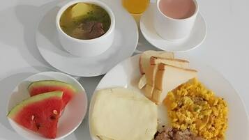 Une assiette de petit-déjeuner avec des toasts, des œufs brouillés et une portion de viande.