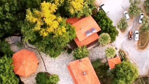 An aerial view of a residential area with houses, a swimming pool, and parked cars. - Uyku Vadisi Otel (Milas)