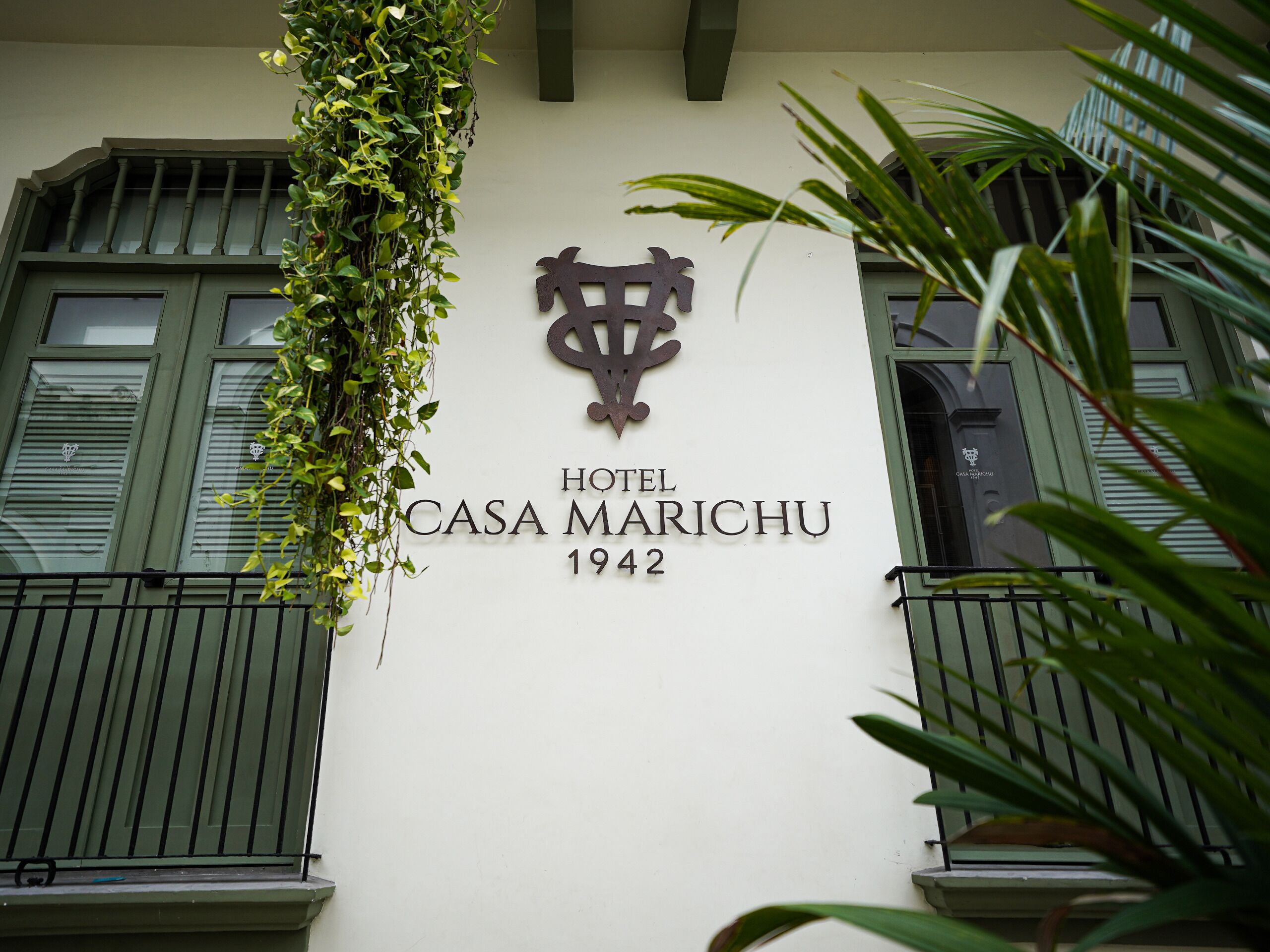 Un edificio con un letrero que dice 'HOTEL CASA MARICHU 1942' y un emblema decorativo encima del texto.