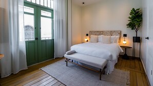 A bedroom with a bed, bedside lamps, a green door, and a plant. - Hotel Boutique Casa Marichu -Incredible Studio With Pool, Rooftop and Balcony M6 (Ciudad de Panamá)