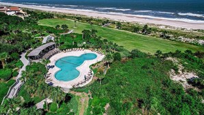 An aerial view of a resort with a large swimming pool, a beach, and lush greenery. - Heated Pool, Ocean Views, Pet-Friendly Paradise (Fernandina Beach)
