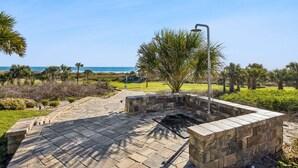 A paved outdoor area with a stone bench, a metal lamp post, and a view of the ocean. - Heated Pool, Ocean Views, Pet-Friendly Paradise (Fernandina Beach)