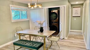 A dining area with a wooden table, cushioned bench, and chairs.
