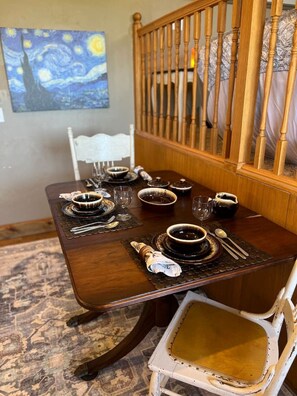 Une table à manger dressée avec de la vaisselle, des verres et des couverts.