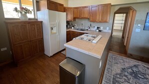 A kitchen with wooden cabinets, a white refrigerator, a stove, and a sink. - Starlight Casita Durango (Durango)