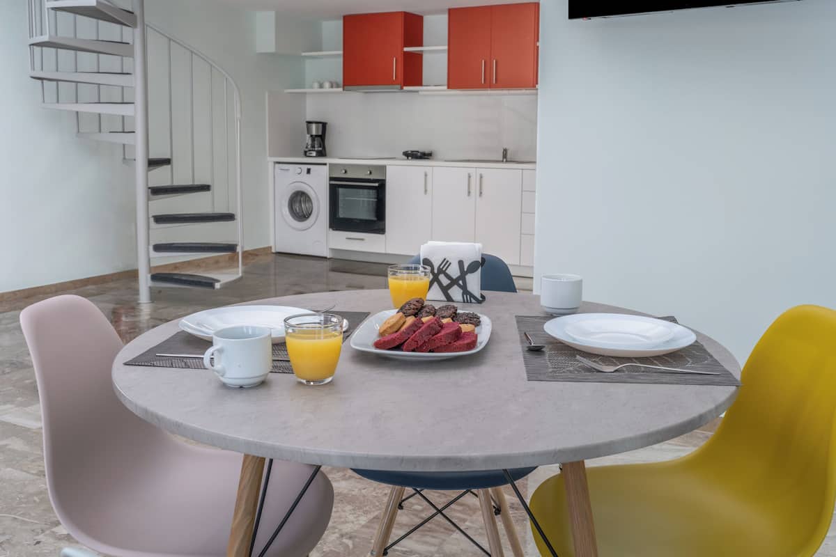 Een moderne keuken met witte kastjes, een inbouwoven en een koffieapparaat.