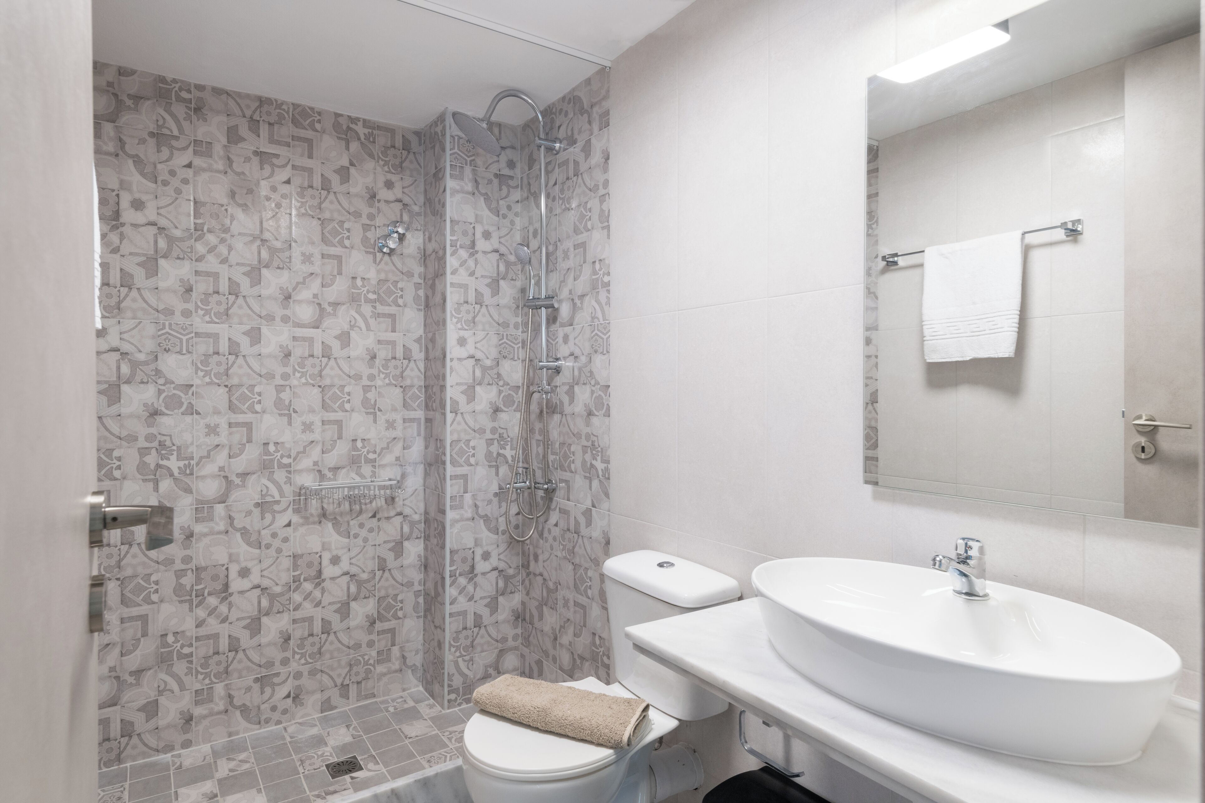 Een badkamer met een douche, toilet en wastafel.