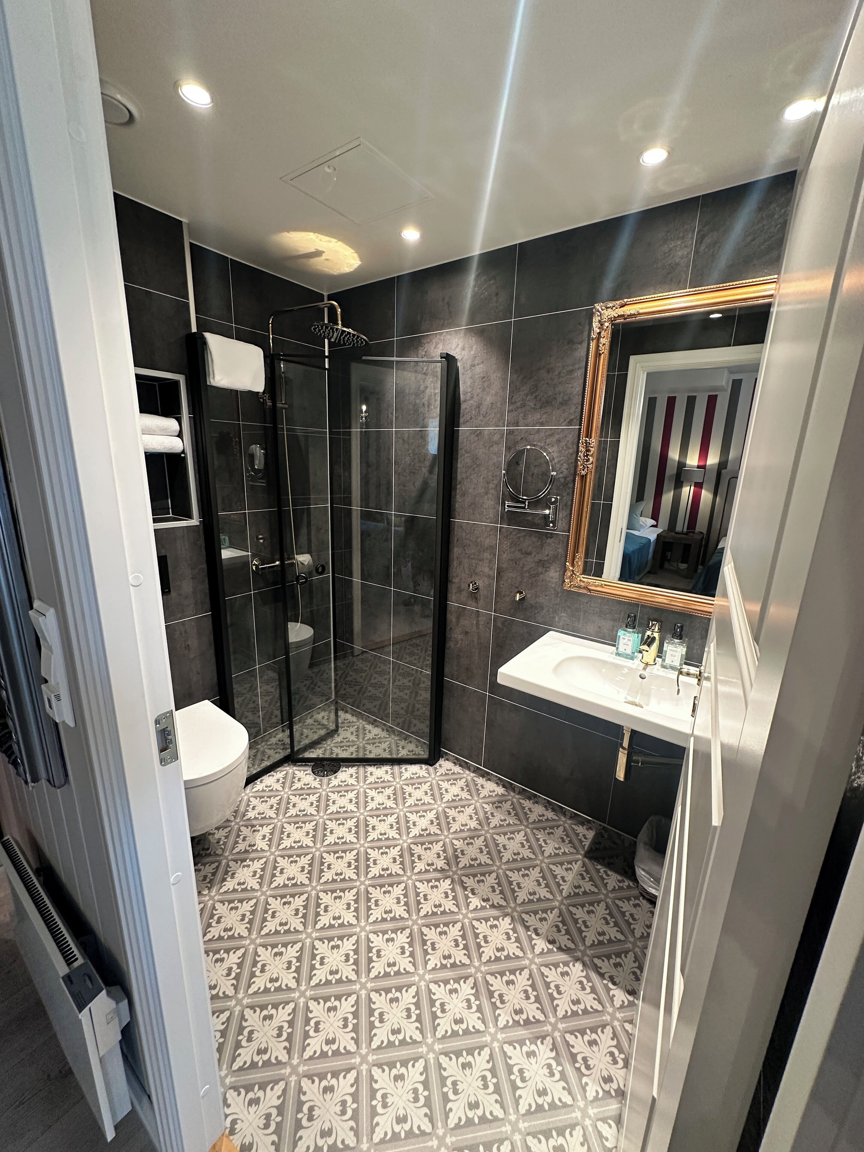 Une salle de bain moderne avec une douche à parois de verre, des toilettes et un lavabo.