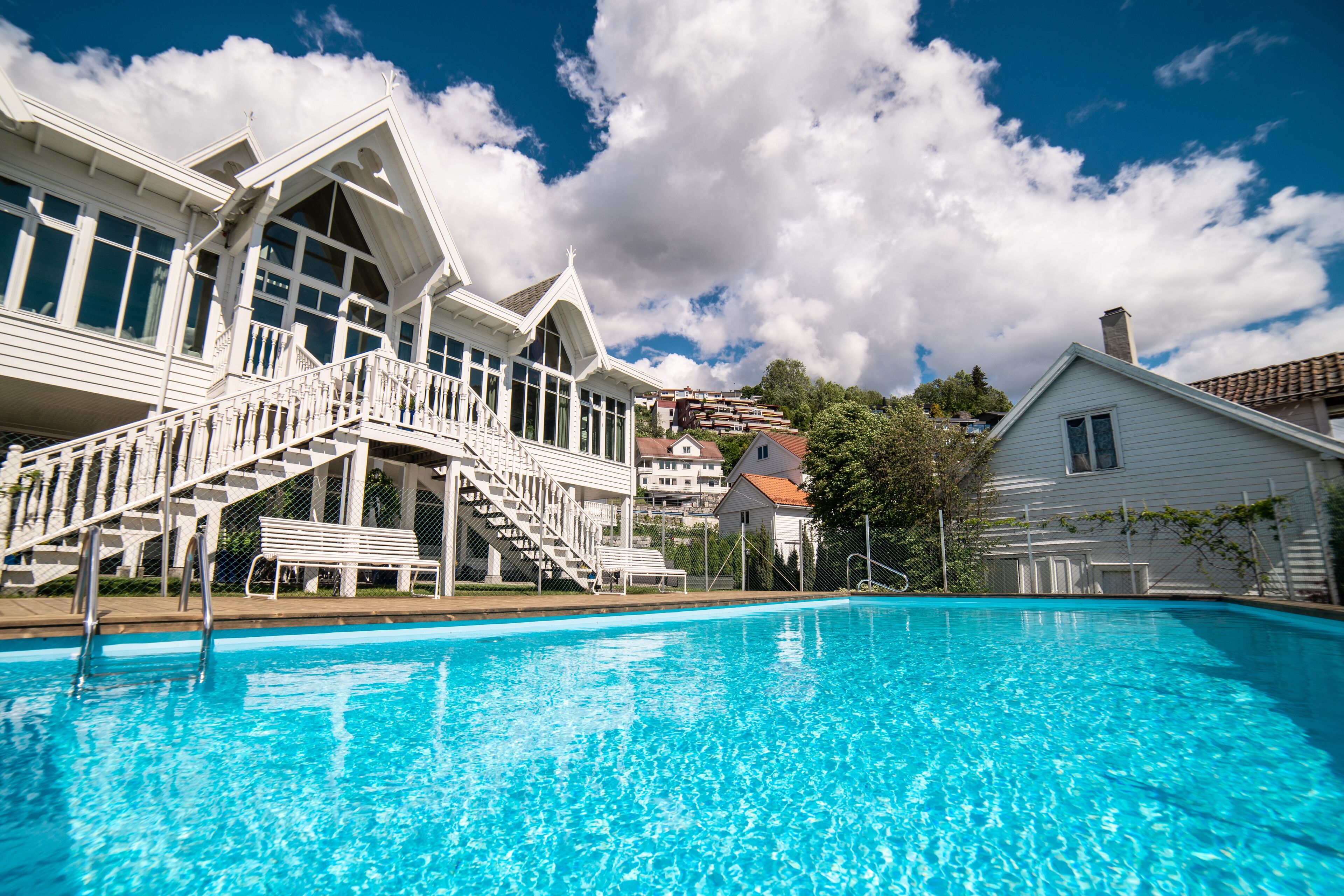 A swimming pool with a white building in the background.