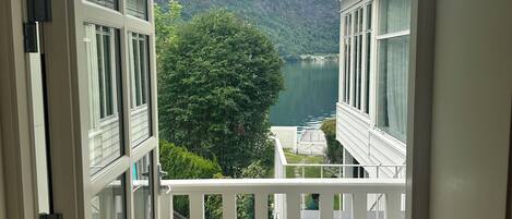 A balcony with a view of a lake and mountains.
