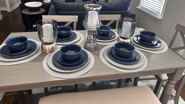 A dining table set with blue and white plates and bowls, a silver candle holder, and a clear glass. - Minutes from Birmingham and Hoover! Enjoy with Family for Fun & Fellowship (Birmingham)