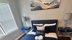 A bedroom with a bed, pillows, a bedside table, a lamp, and a painting on the wall. - Minutes from Birmingham and Hoover! Enjoy with Family for Fun & Fellowship (Birmingham)