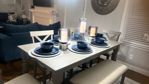A dining table set with blue plates and candles, surrounded by chairs. - Minutes from Birmingham and Hoover! Enjoy with Family for Fun & Fellowship (Birmingham)