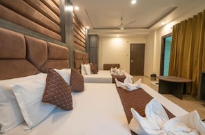 Habitación de hotel con dos camas, un ventilador de techo y una mesita.