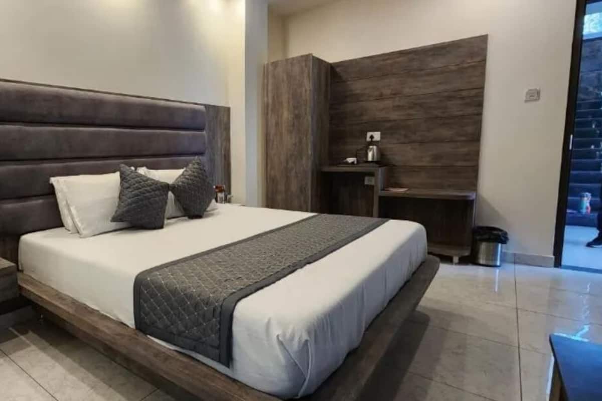 Un dormitorio moderno con una cama grande, una mesita de noche y un cabecero de madera.