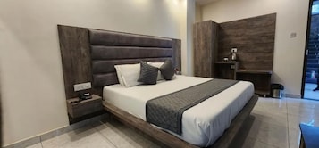 A modern bedroom with a large bed, a nightstand, and a wooden headboard.