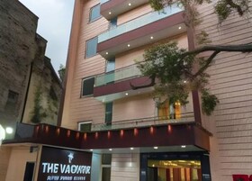 Un edificio de varios pisos con fachada moderna, un escaparate visible con letreros y balcones en cada planta.