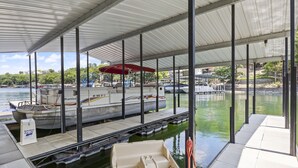 Un quai abrité où est amarré un bateau, ainsi qu’un petit canot.