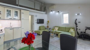 A modern apartment with a kitchen, dining area, living room, and a balcony. - Beach front home in Sveti Ivan with WiFi (Sveti Ivan)