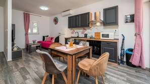 A compact kitchen with dark cabinets, a microwave, and a sink. - Awesome home in Peroj (Peroj)