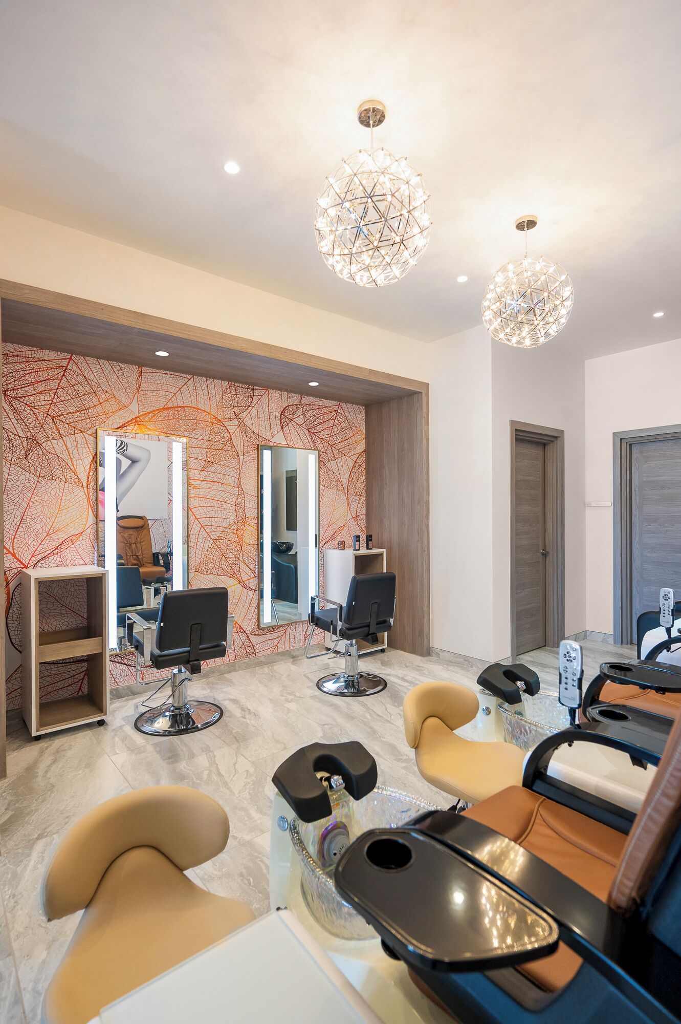 Un salon moderne doté de plusieurs postes de coiffure, d’un grand miroir et d’une décoration contemporaine.