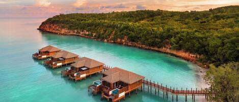 Overwater bungalows connected by a wooden walkway.
