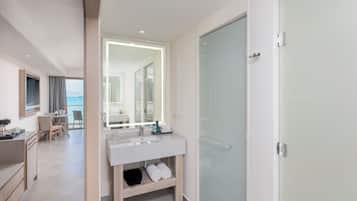 A modern bathroom with a glass shower door, a large mirror, and a vanity with a sink.
