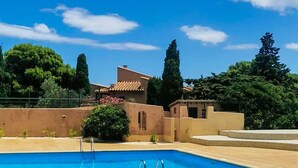 A clear blue sky with a swimming pool and a building with a tiled roof. - Natural Escape: Air-Conditioned T2 BIS, Pools, and Private Estate in Fitou! (Fitou)