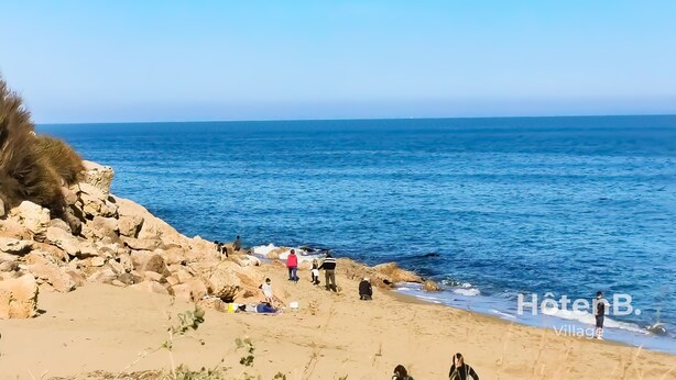 A beach with rocky terrain and people near the water. - Natural Escape: Air-Conditioned T2 BIS, Pools, and Private Estate in Fitou! (Fitou)